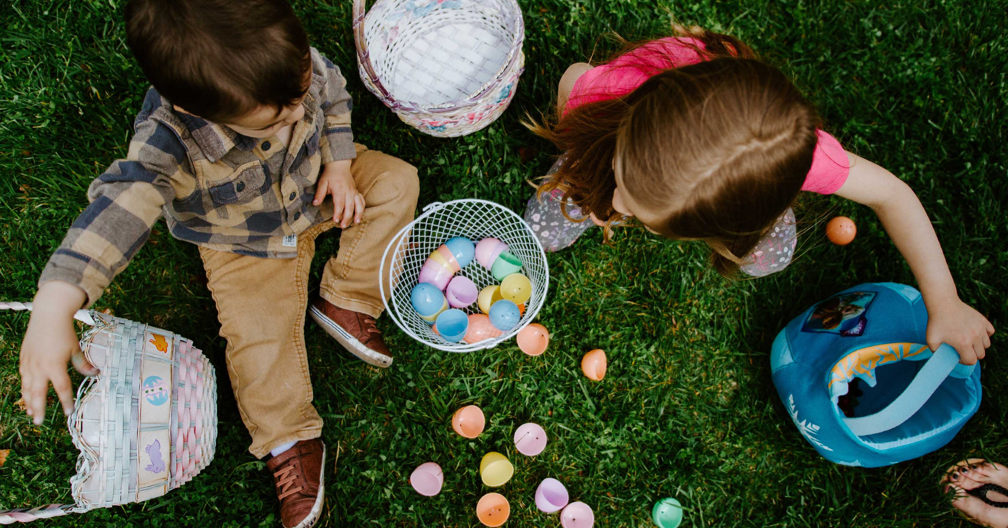 Kids sitting on grass playing with easter eggs in their St Clair townhome by AVJennings located in St Clair, SA 5011. Townhomes for sale in St Clair.
